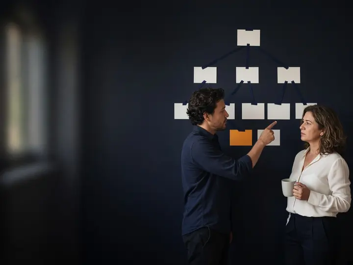 Dupla revisando o mapa de páginas do site pregado na parede